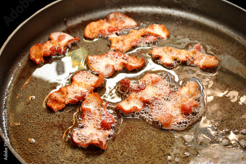 Fotografie Fatty Bacon Frying in a Pan