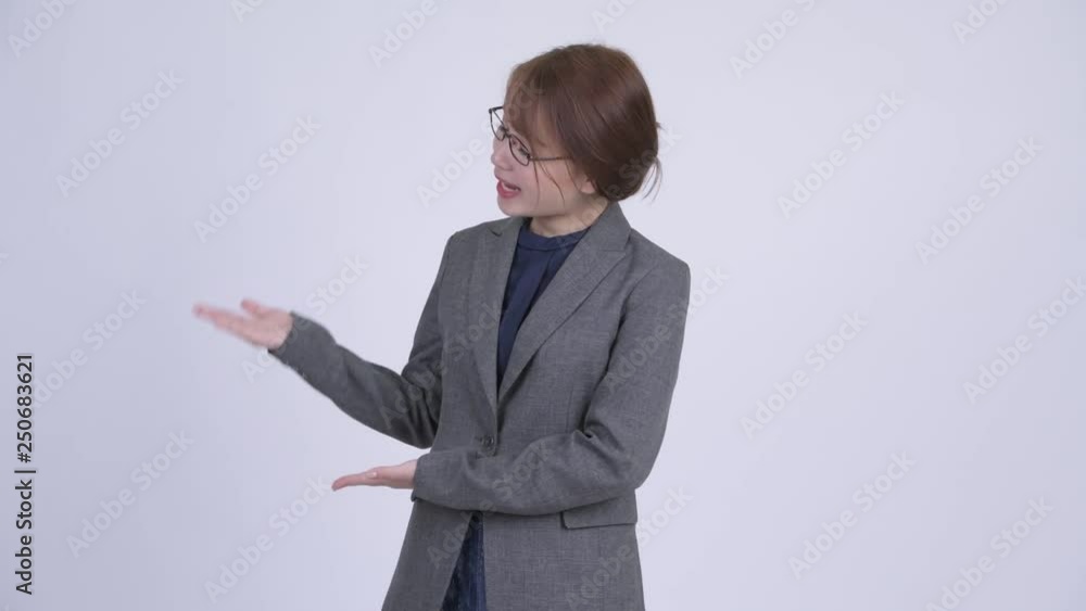 Young beautiful Asian businesswoman presenting something Young beautiful Asian businesswoman presenting something