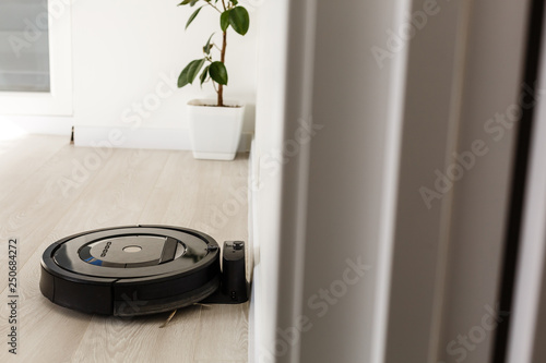 Robot vacuum cleaner return to charging at dock in clean room floor photo