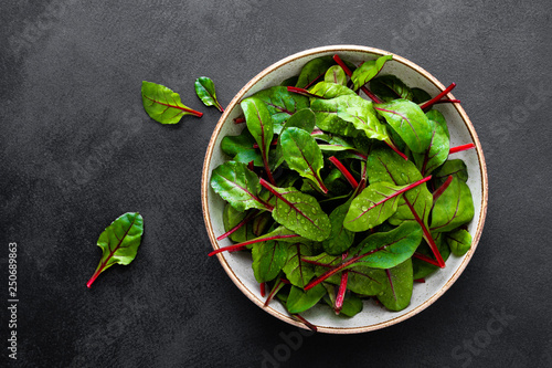 Quadro em tela Fresh chard leaves on black background top view