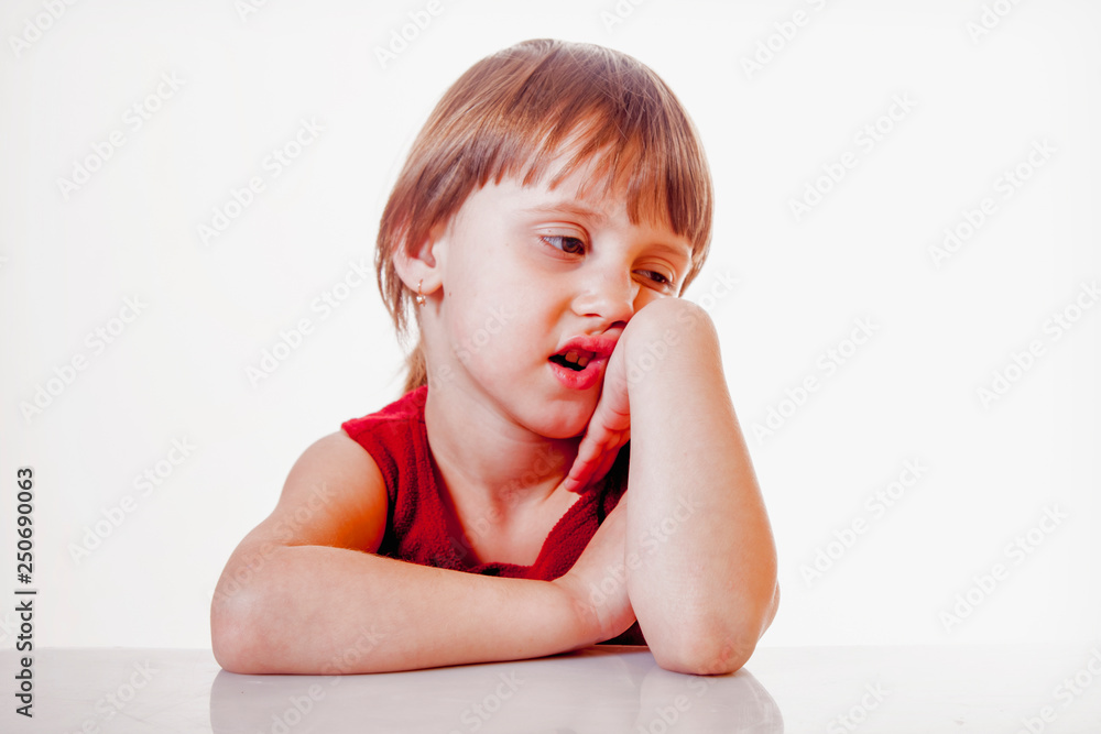 Bored little cute child girl holding hand on cheek, looking tired and sick, over white background. Negative emotions, gestures, body language concept. Bored little cute child girl holding hand on cheek, looking tired and sick, over white background. Negative emotions, gestures, body language concept.