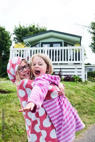 Two sisters playing outside there static holiday home cuddling and playing
