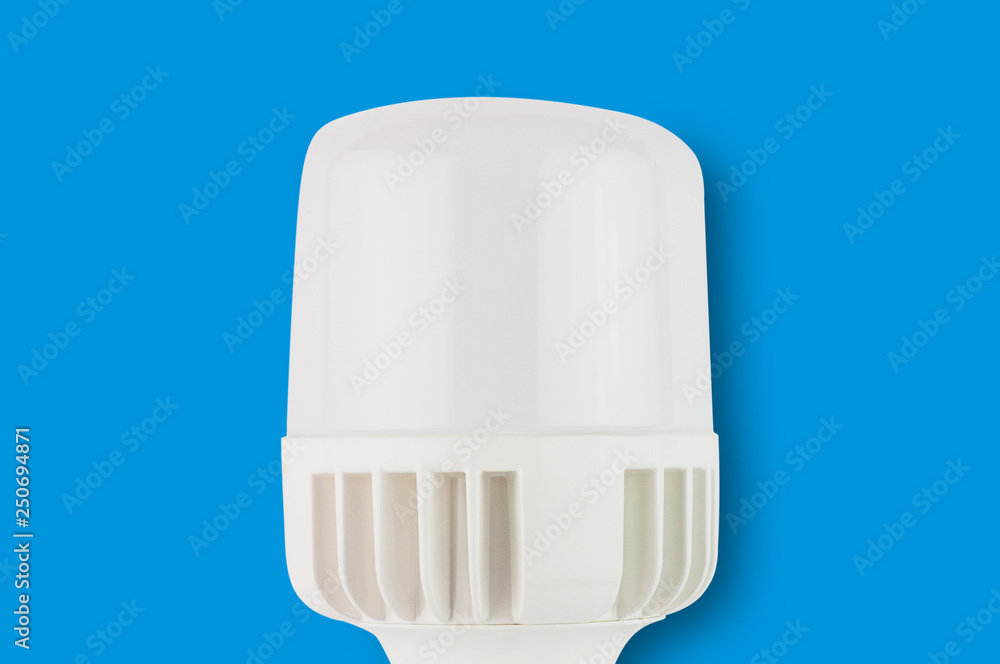 One new plastic led bulb in center on blue background. Top view One new plastic led bulb in center on blue background. Top view