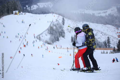 Two skiers on a ski slope in winter holidays