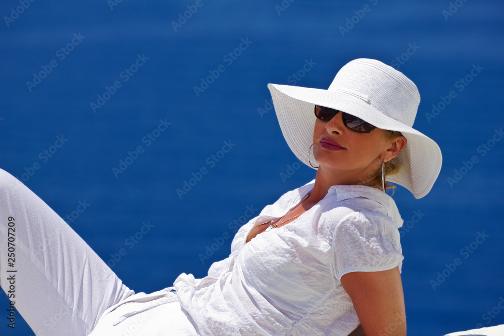 woman in white hat on background of blue sea