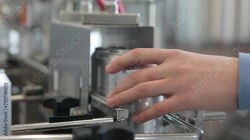 Conveyor for filling aluminum cans. Banks move along the conveyor and the person sorts them.