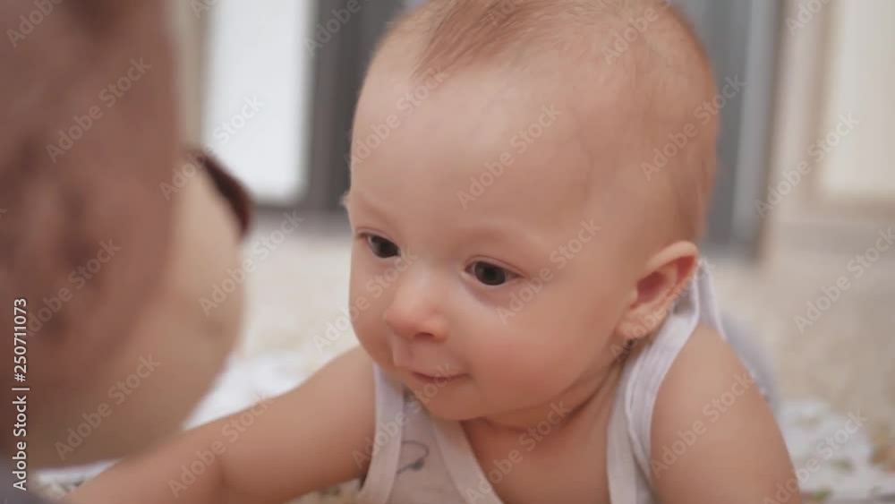 Infant boy playing with teddy bear on a white carpet at home. Infant boy playing with teddy bear on a white carpet at home.