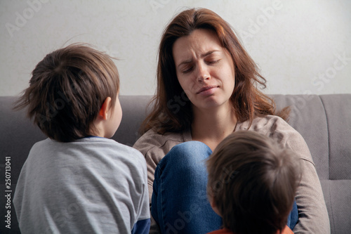  Woman mom is tired in depression and children are boys.