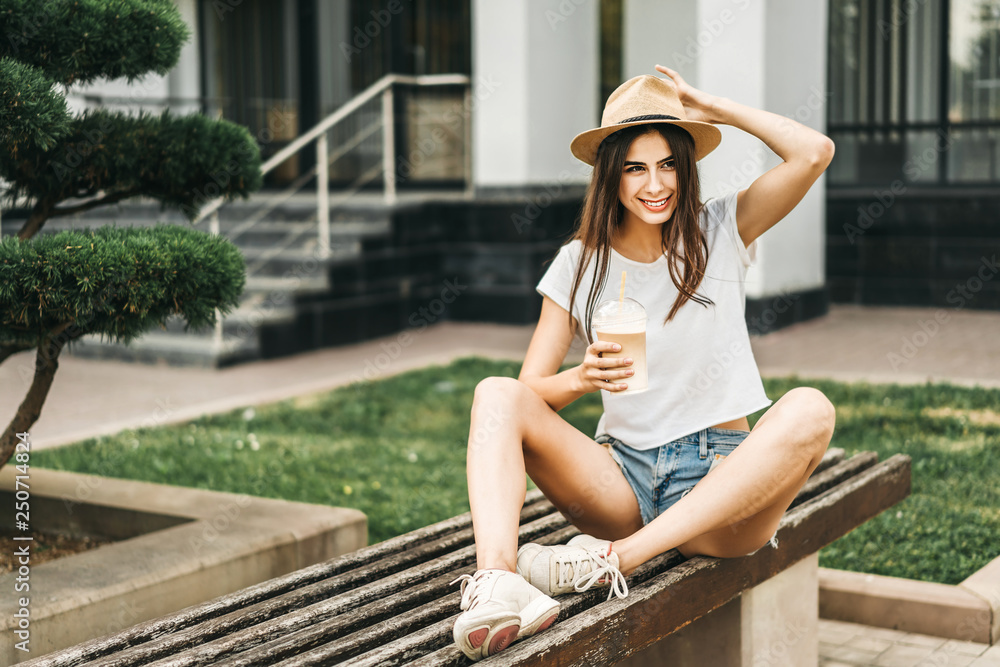 Obraz premium Brunette pretty tourist girl outdoor with cup of cold coffee.