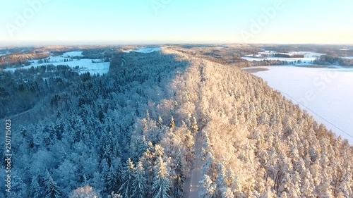 Flying above frozen forest above the road in the middle of the ridge photo