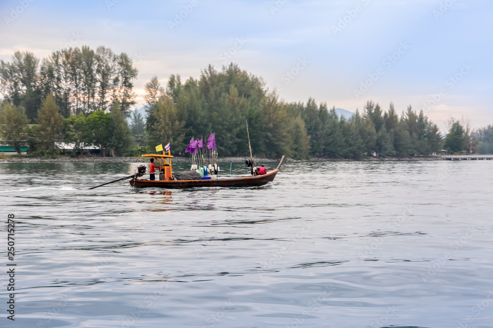 Phang Nga / Thailand - December 23, 2015. Tab Lamu river, Thai Mueang. Thai fishermen go fishing early in the morning at sunrise. Fishing boat is on the river against the backdrop of the jungle.