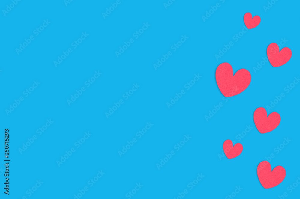 Many scattered red paper hearts on blue table. Top view. Valentines Day concept. Copy space for your text