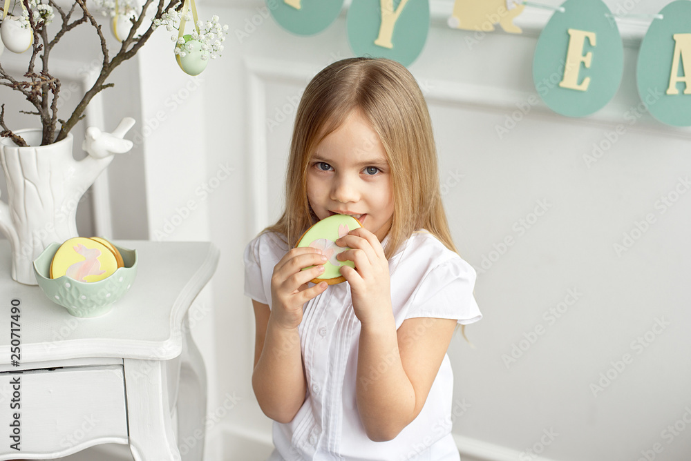 Beautiful child is eating gingerbread eggs. Happy family preparing for Easter. Beautiful child is eating gingerbread eggs. Happy family preparing for Easter.