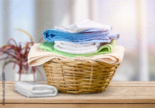 Laundry Basket with colorful towels on background