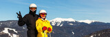 Happy man and woman skiers against the background of snowy mountains