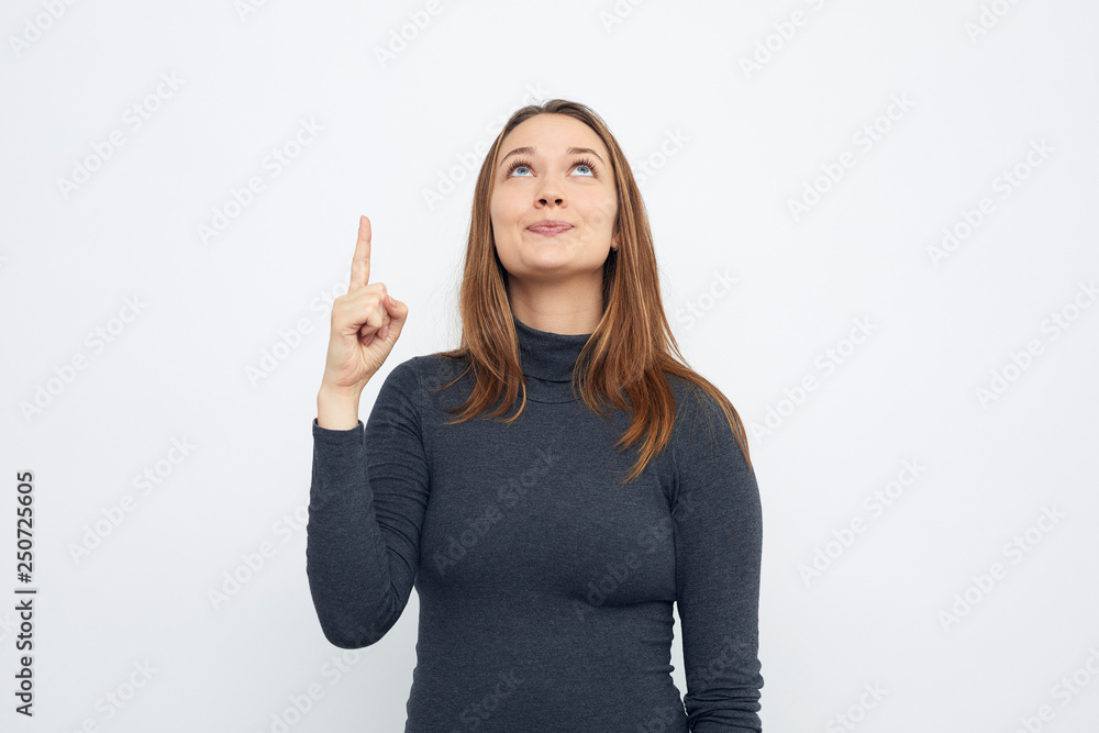 portrait of young smiling woman pointing up looking up portrait of young smiling woman pointing up looking up