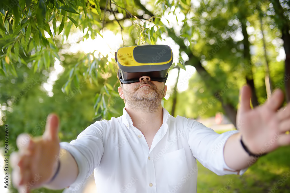 Mature man using virtual reality headset outdoor. VR, VR glasses, augmented  reality experience. Stock Photo | Adobe Stock