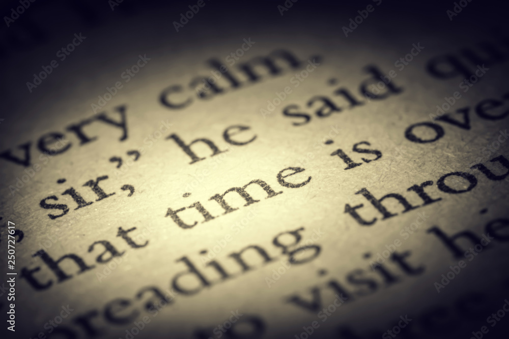 The word time on old page in a open book close-up macro. Vintage, grunge, old, retro style photo. The word time on old page in a open book close-up macro. Vintage, grunge, old, retro style photo.