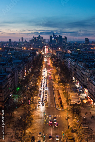 Magnificent look from Arc de Triomphe (Triumphal Arc) towards the La défense at sunset - the parisien trade quarter, the streets are lighten by the cars and street lamps