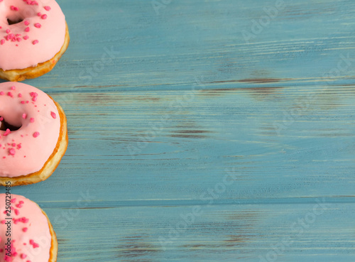 Photo of pink donuts on a blue background. Frame for text with donuts and sweets. Basis for a banner with donuts. Banner with donuts for social networks, shops, cafes