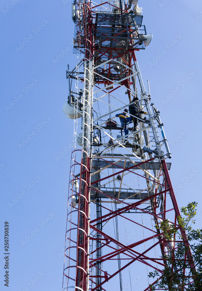 Two Welders Working On High Telecommunication Tower.