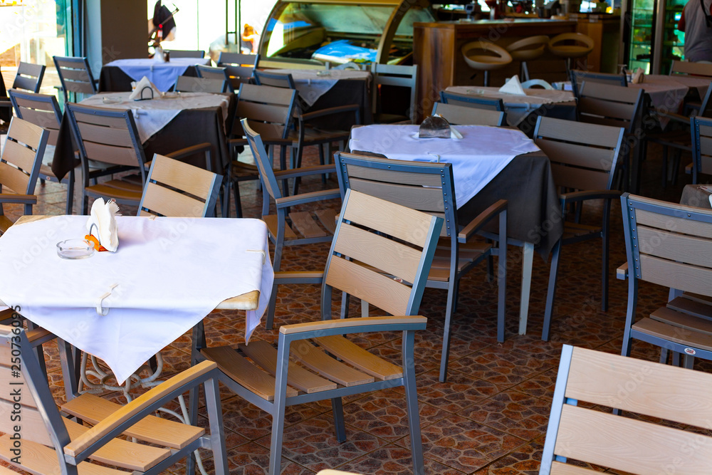 Tables in the restaurant with white table cloth and white napkins in the holder