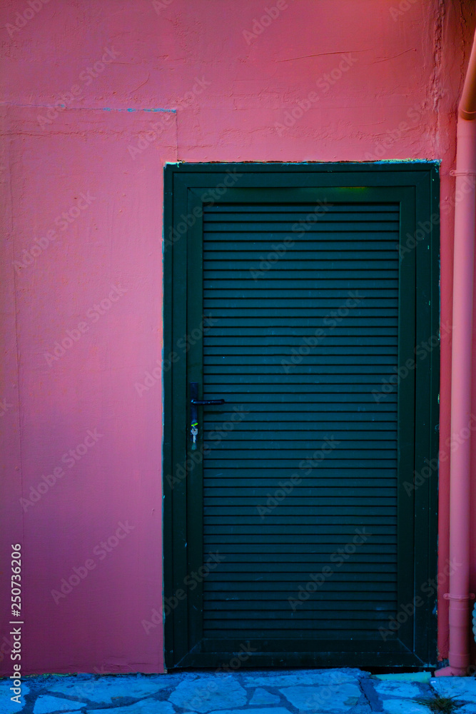 Green wooden doors to the room. Closed doors on the red wall. Copy space on the wall Green wooden doors to the room. Closed doors on the red wall. Copy space on the wall