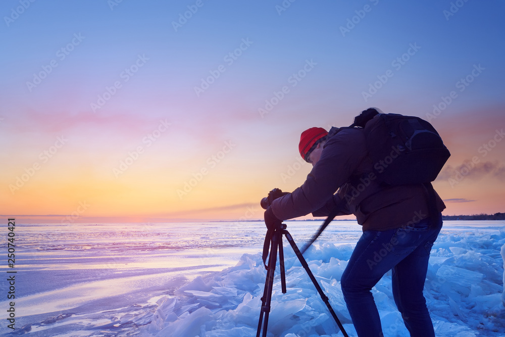the photographer is shooting a winter sunrise  early morning sunrise on the frozen river
