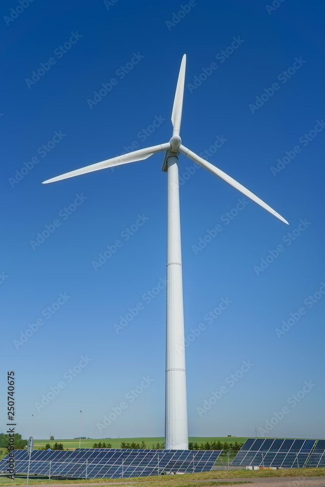 Wind generator turbine and solar panels of a battery on blue sky, alternative energy sources. Wind generator turbine and solar panels of a battery on blue sky, alternative energy sources.