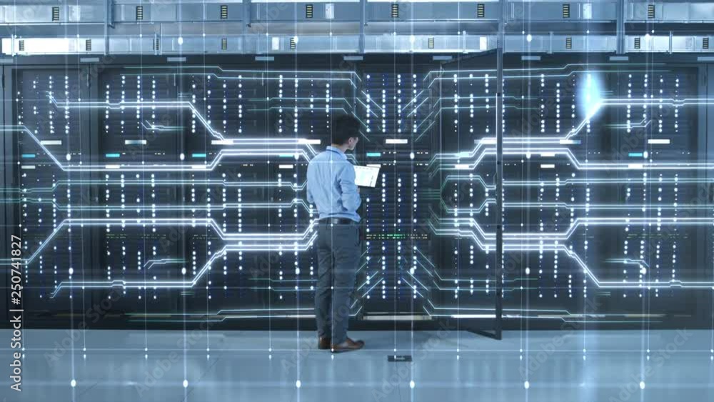 IT Specialist Standing In front of Server Racks with Laptop, He ...