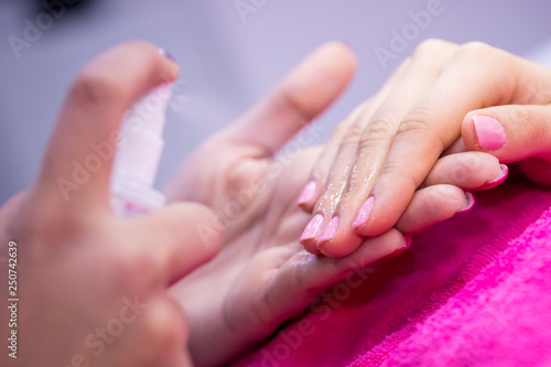 Women's hands on pink towel in nail salon