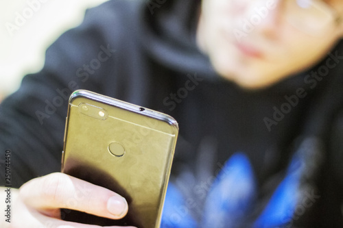 teenager looks at her mobile phone worriedly