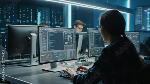 Smart Female IT Programer Working on Desktop Computer in Data Center System Control Room. Team of Young Professionals Doing Code Programming photo