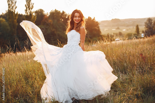Beautiful bride walking in a summer field