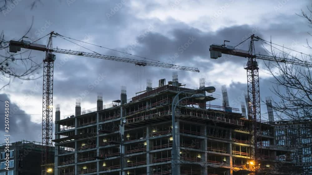 Cranes working day and night on construction of the housing estate in former industrial zone, time lapse Cranes working day and night on construction of the housing estate in former industrial zone, time lapse