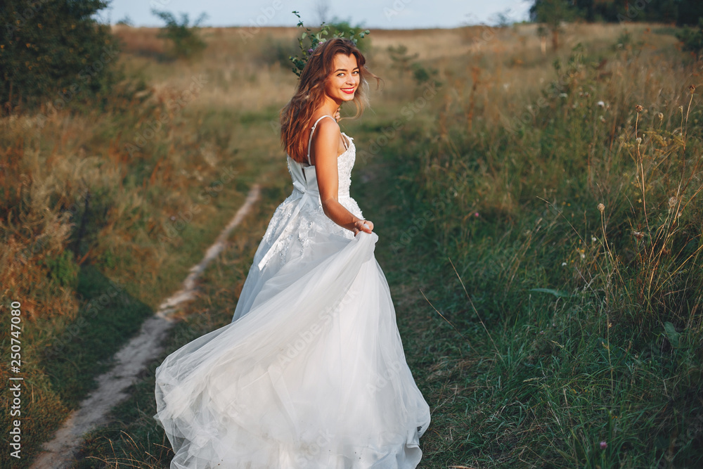 Beautiful bride walking in a summer field Beautiful bride walking in a summer field