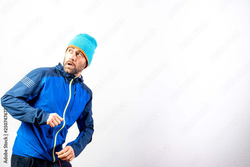 Simple portrait and white background of mountaineer with winter hat with gesture of surprise before a danger.