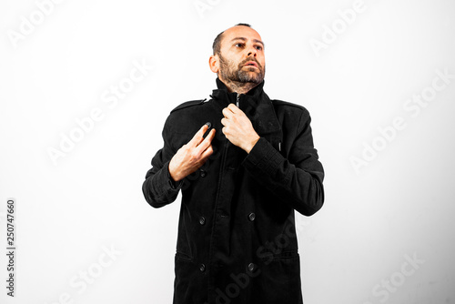 Simple and clean portrait of middle-aged man wearing his black raincoat to hide his face. photo