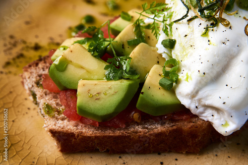 Fresh Avocado Toast and Poached Egg with Baked Tomatoes, close-up