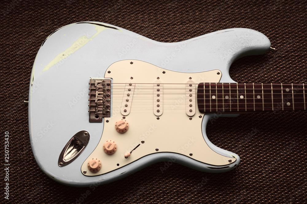 Naklejka premium White pearl ivory electric guitar in a purple texture background.