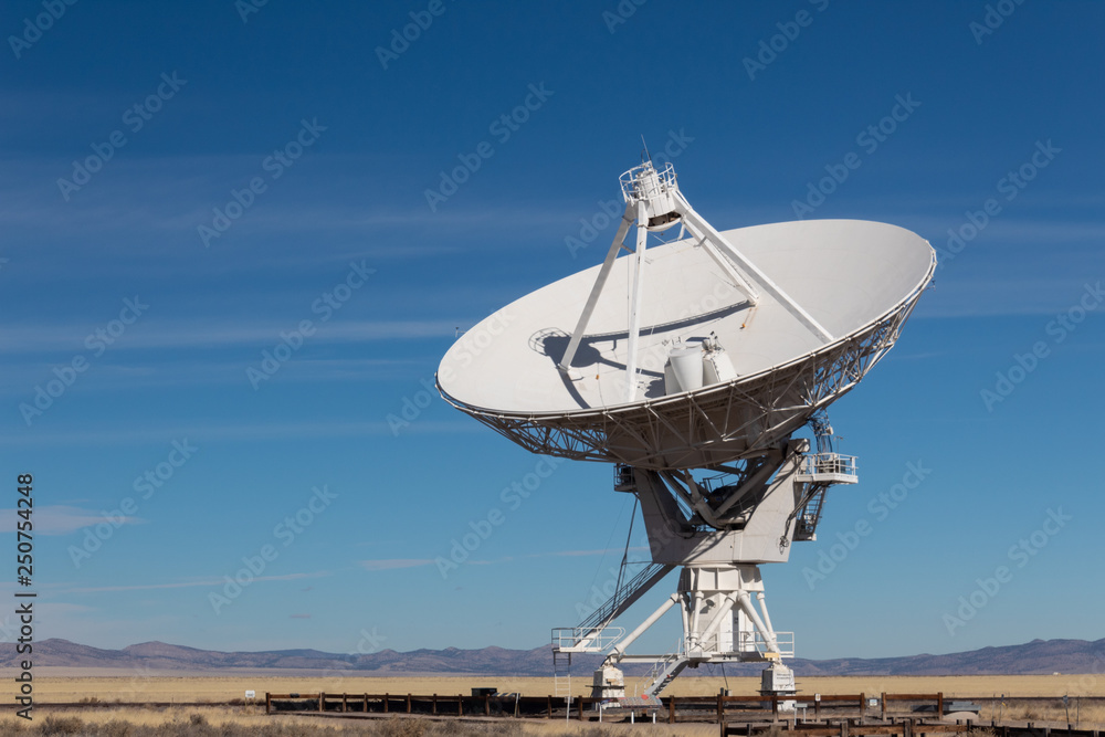 Very Large Array VLA radio antenna dish against a blue sky in the New Mexico desert, technology space exploration science, horizontal aspect