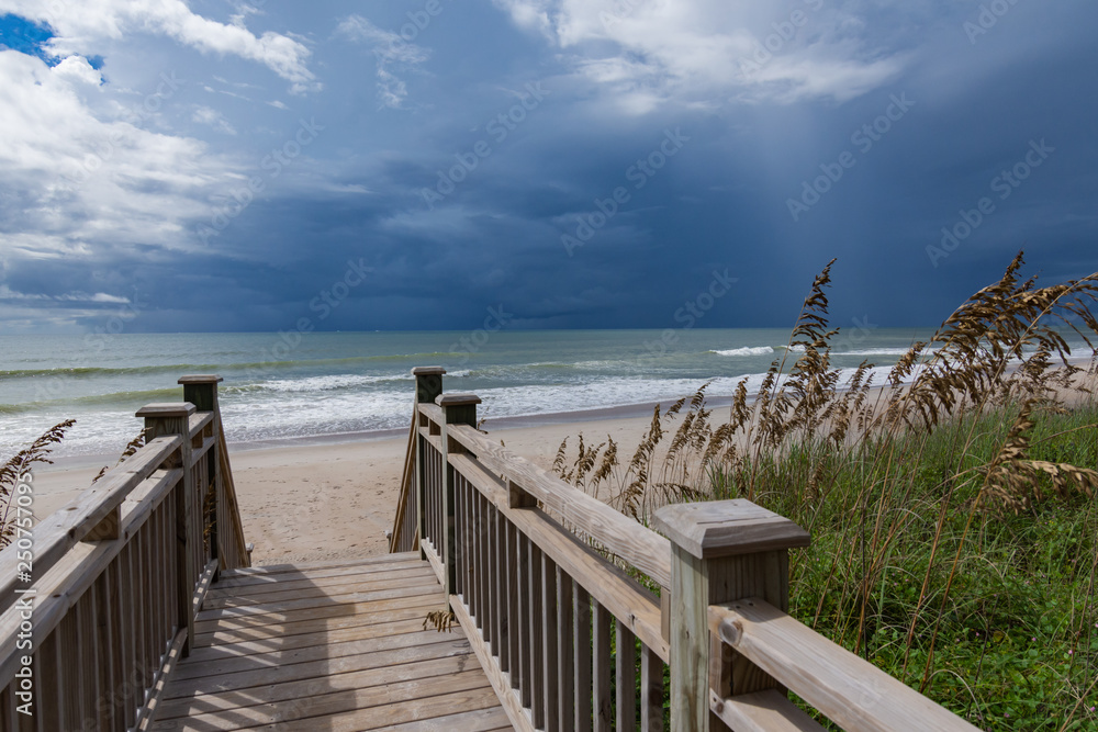 Beach acces walkway leading to a stormy seascape