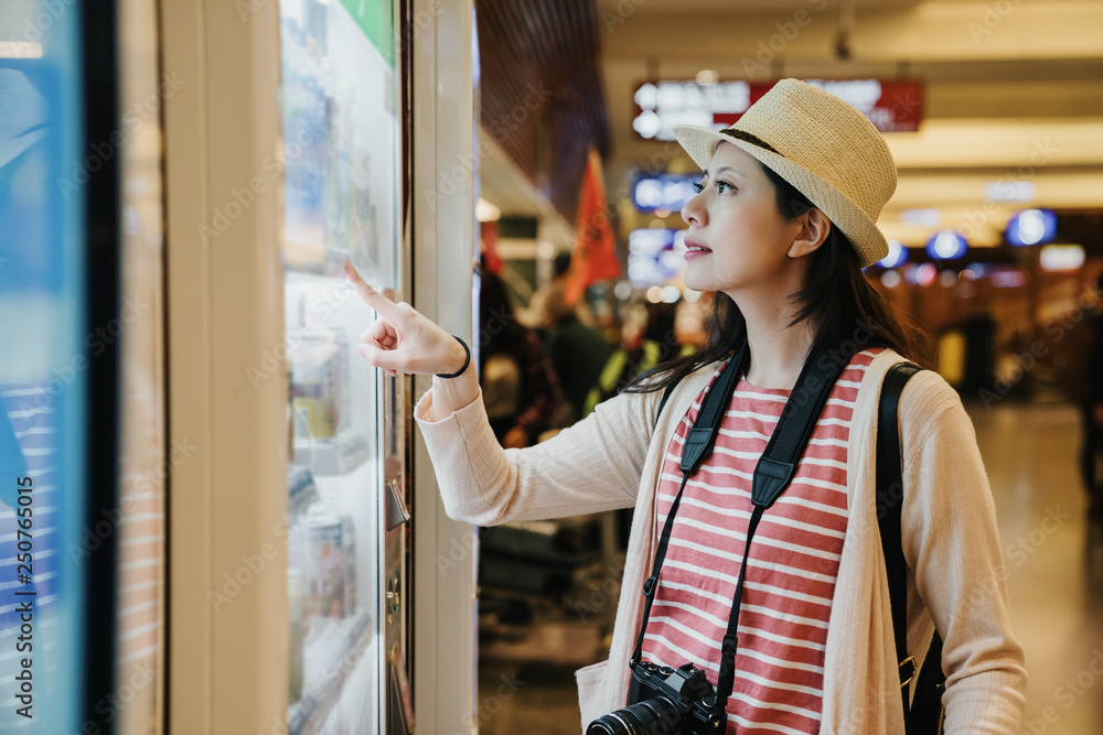 Φωτογραφία asian travel woman photographer using modern vending machine in airport while waiting for plane flight in departure gate