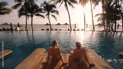 couple relaxing in luxurious beach hotel near swimming pool