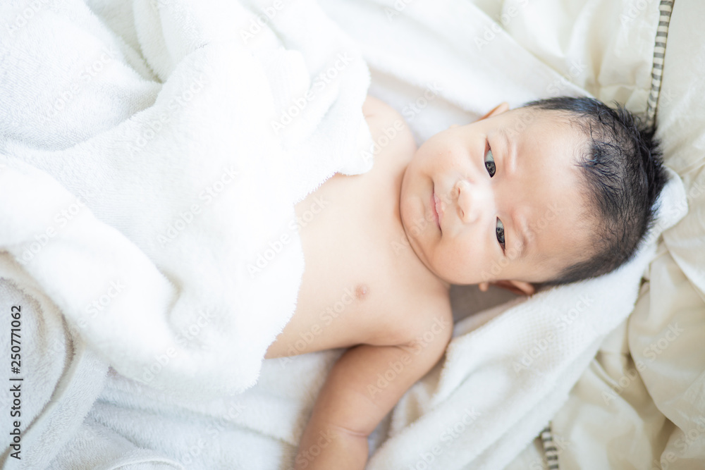 Asian baby boy lying on white blanket morning wake up