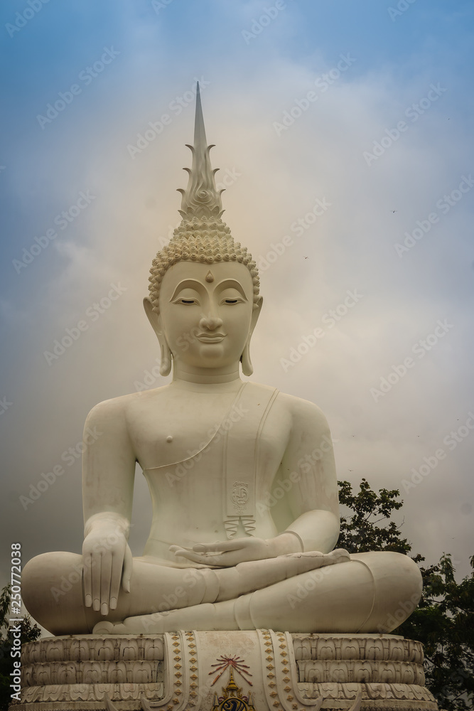 Beautiful big white buddha statue against blue sky and white cloud at the public forest temple, Wat Phu Phlan Sung, Nachaluay, Ubon Ratchathani, Thailand. Beautiful big white buddha statue against blue sky and white cloud at the public forest temple, Wat Phu Phlan Sung, Nachaluay, Ubon Ratchathani, Thailand.