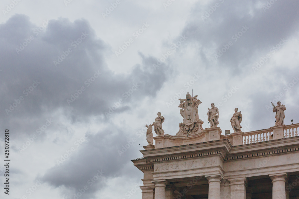 Sculptures under clouds and sky in St. Peter's Square in Vantican City