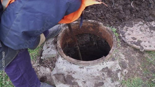 Workers clean manhole and take out dirt and debris