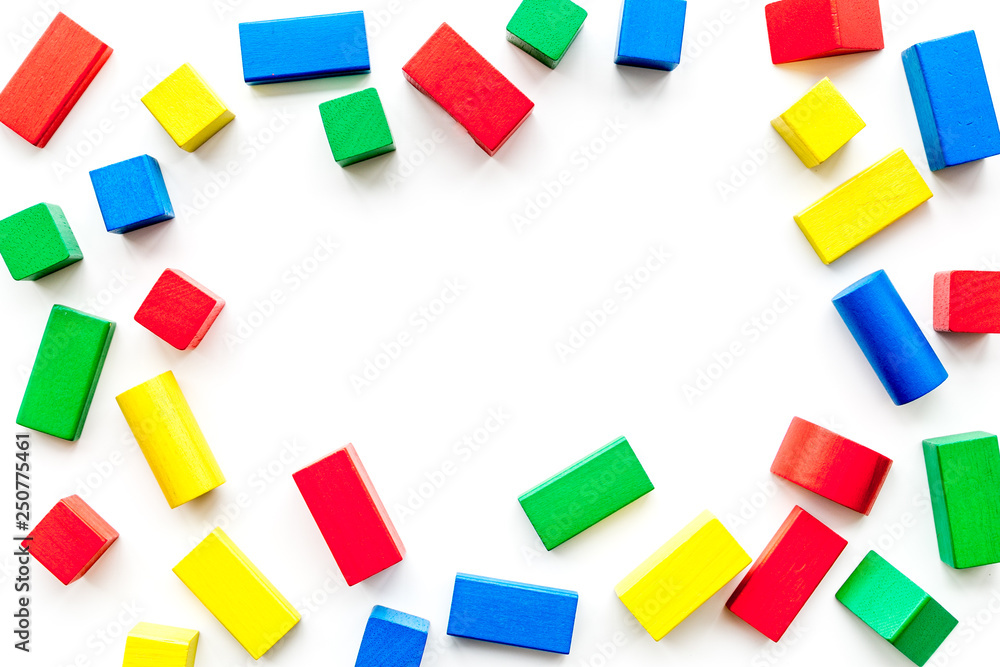 Construction game for kids. Wooden building blocks, toy bricks on white background top view copy space frame Construction game for kids. Wooden building blocks, toy bricks on white background top view copy space frame