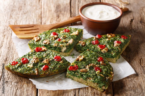 Delicious healthy omelette from herbs, eggs and walnuts and dried berries close-up on a table. horizontal photo